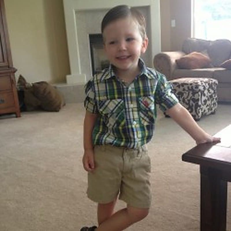 A little boy standing proudly in the living room