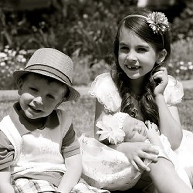 Two of the children dressed up — a boy in a hat beside his sister